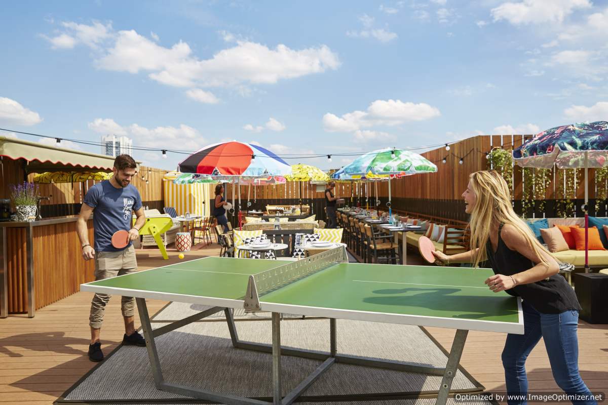 IMAGE: People playing table tennis at Mama Shelter rooftop bar
